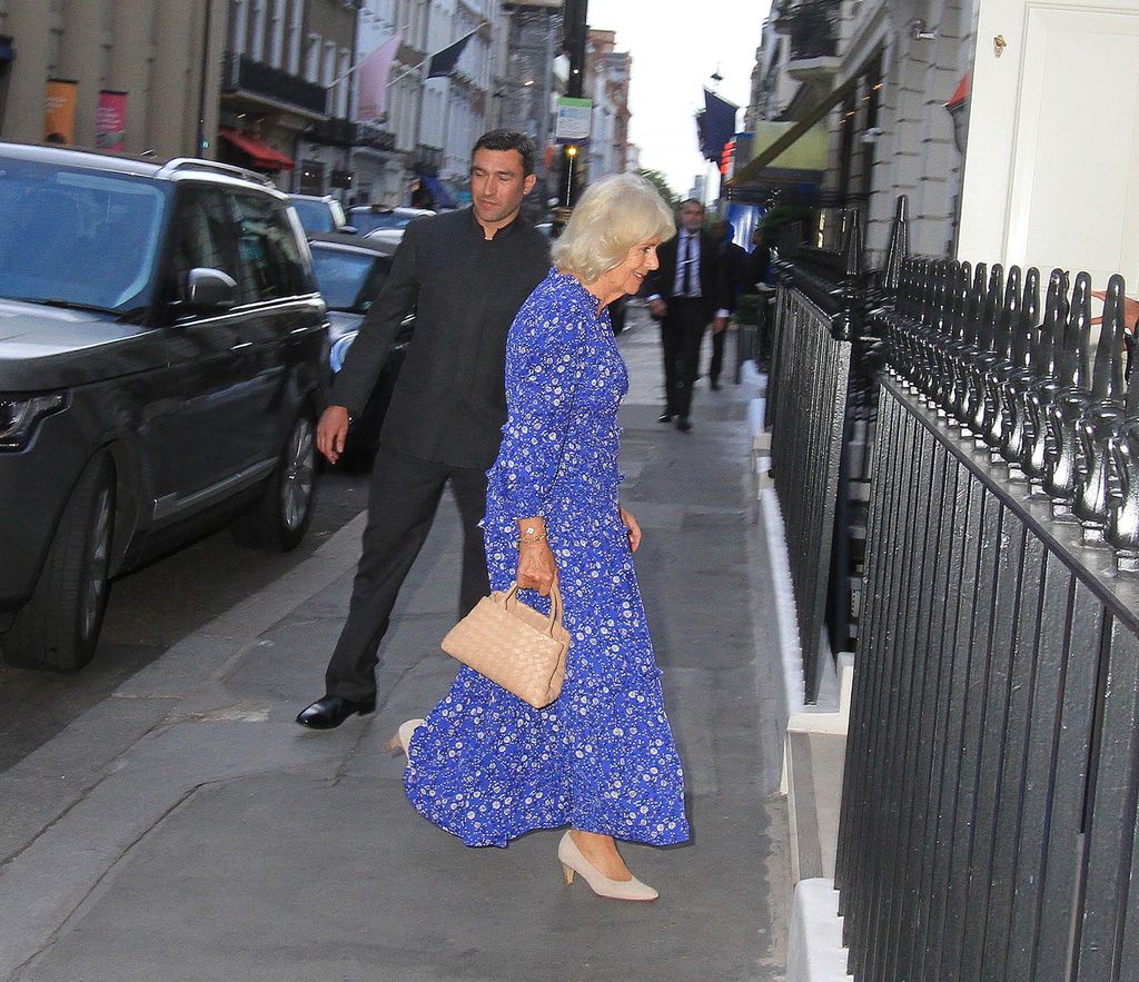 Queen Camilla in a blue dress walking to a club