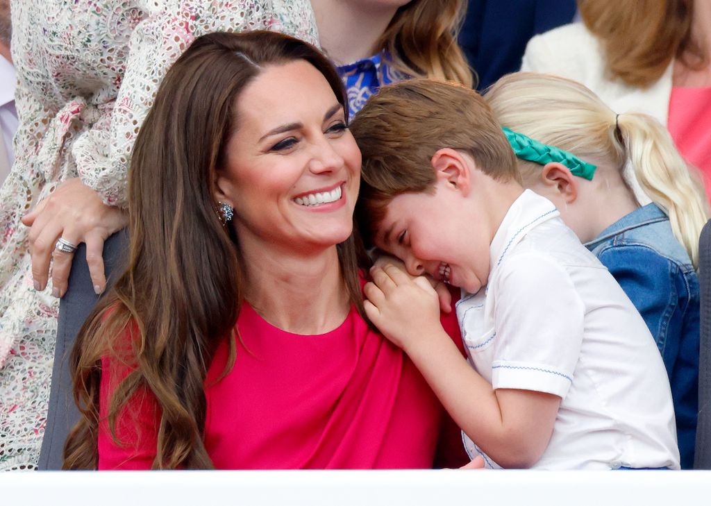 Catherine grinning with Prince Louis with head on her shoulder