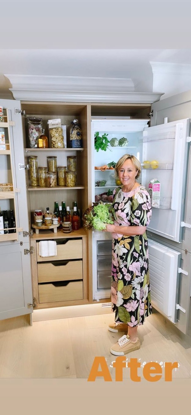 Shirlie Kemp wearing a floral dress in front of a fridge holding a lettuce