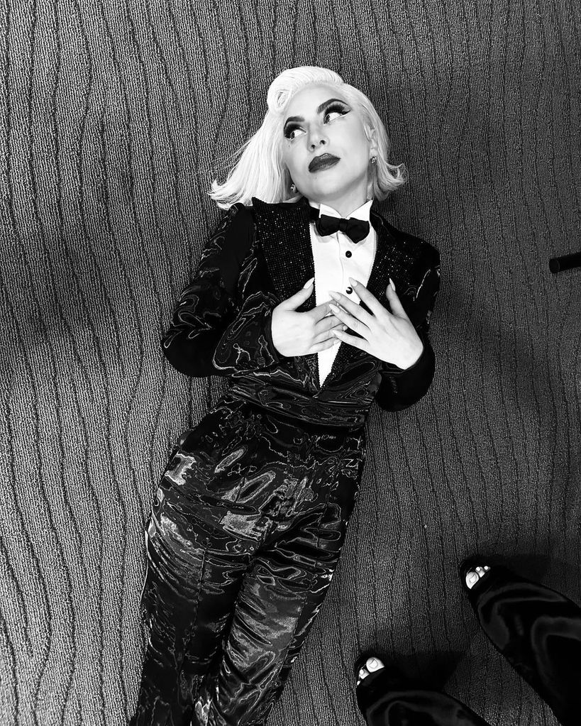 Lady Gaga posing in a tuxedo while backstage at her Jazz + Piano residency