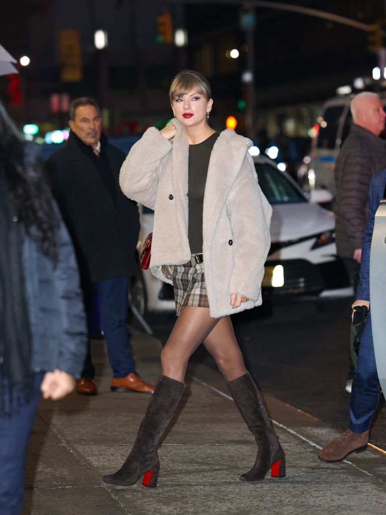 Taylor Swift on dark street in fur coat and tartan mini skirt
