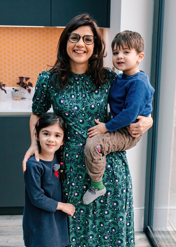 mother holding son and stood next to daughter in kitchen