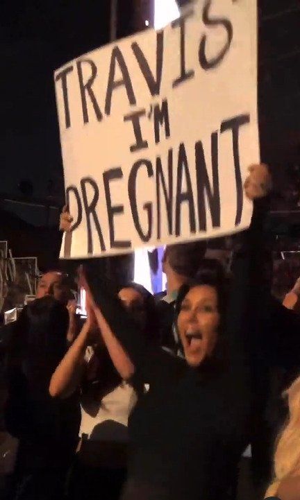 kourtney kardashian holding im pregnant sign