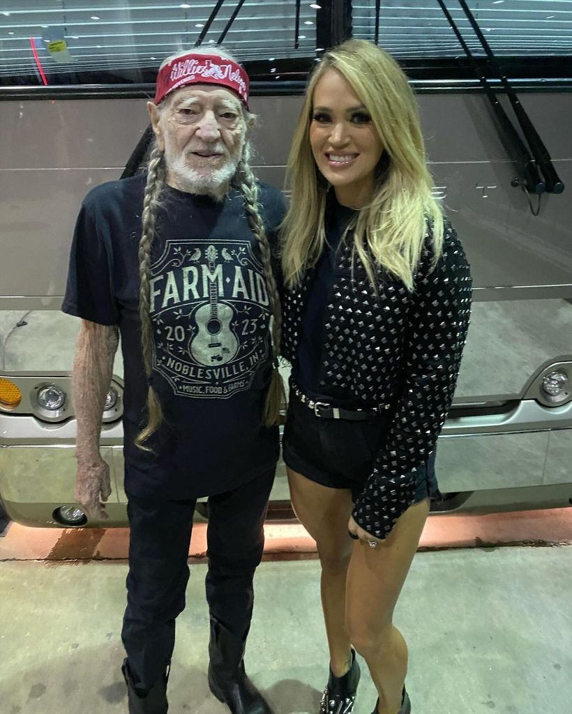Willie Nelson and Carrie Underwood posing together after performing at ATLive