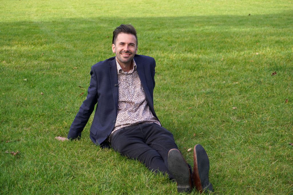 Man in suit sitting on the grass