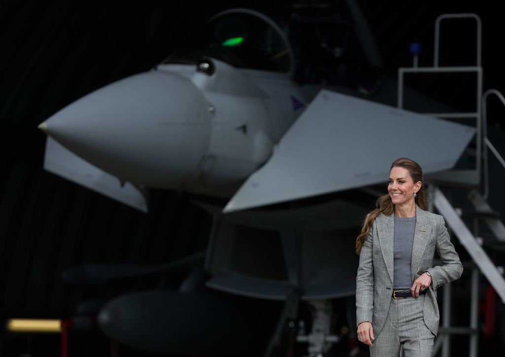 Kate wearing a grey suit standing in front of aircraft