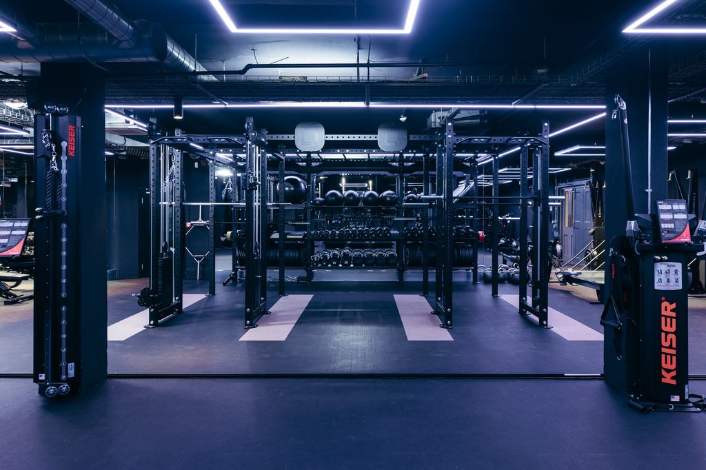 The fully-equipped gym in The Ministry with violet LED lights on the ceiling 