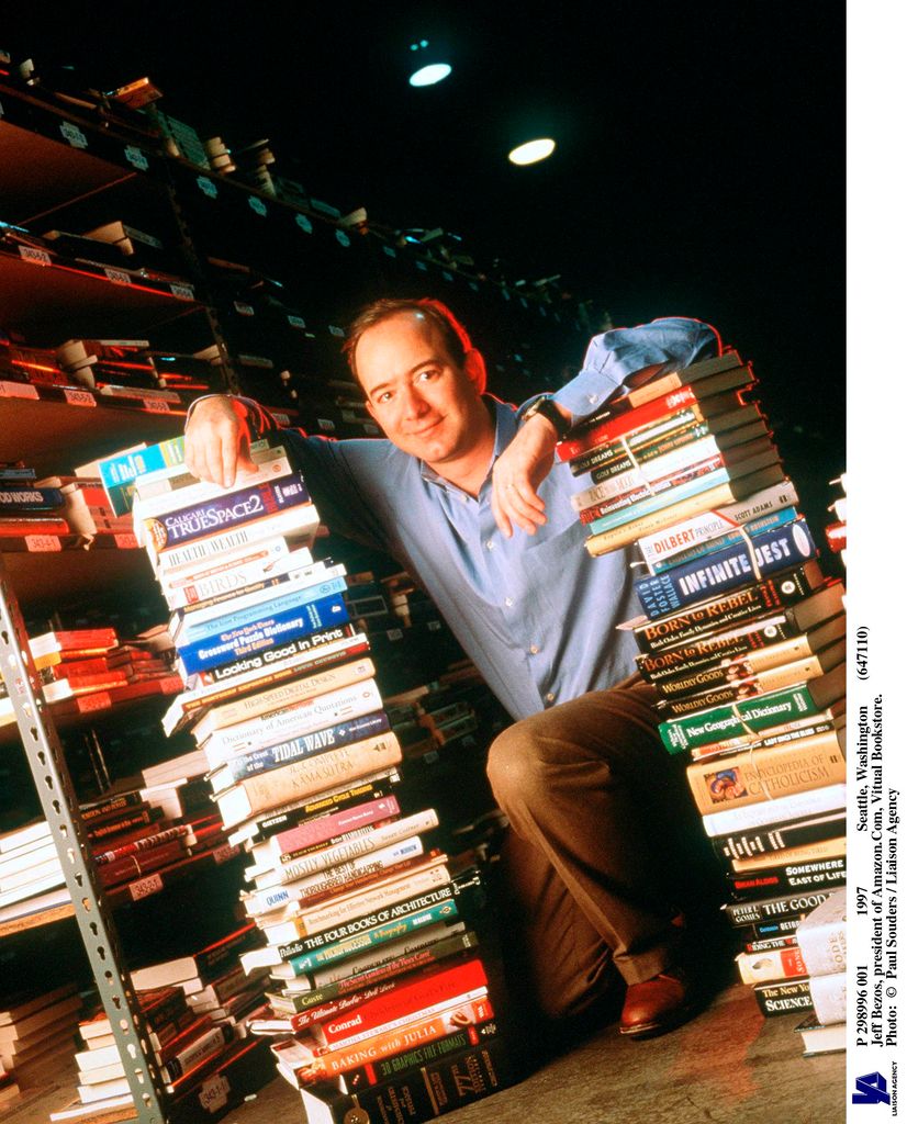 Jeff Bezos, founder & CEO of Amazon.com, poses with a stack of books in an Amazon warehouse, Seattle, Washington, January 1st 1997