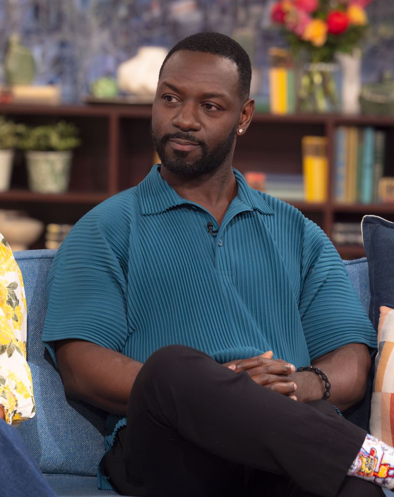 Man in blue shirt sitting on blue sofa in tv studio