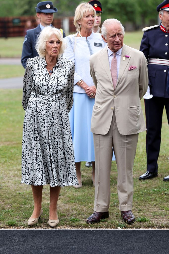 camilla and charles standing on grass in front of group of people