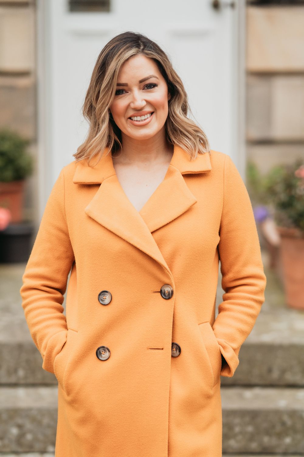 Young woman smiling in an orange coat