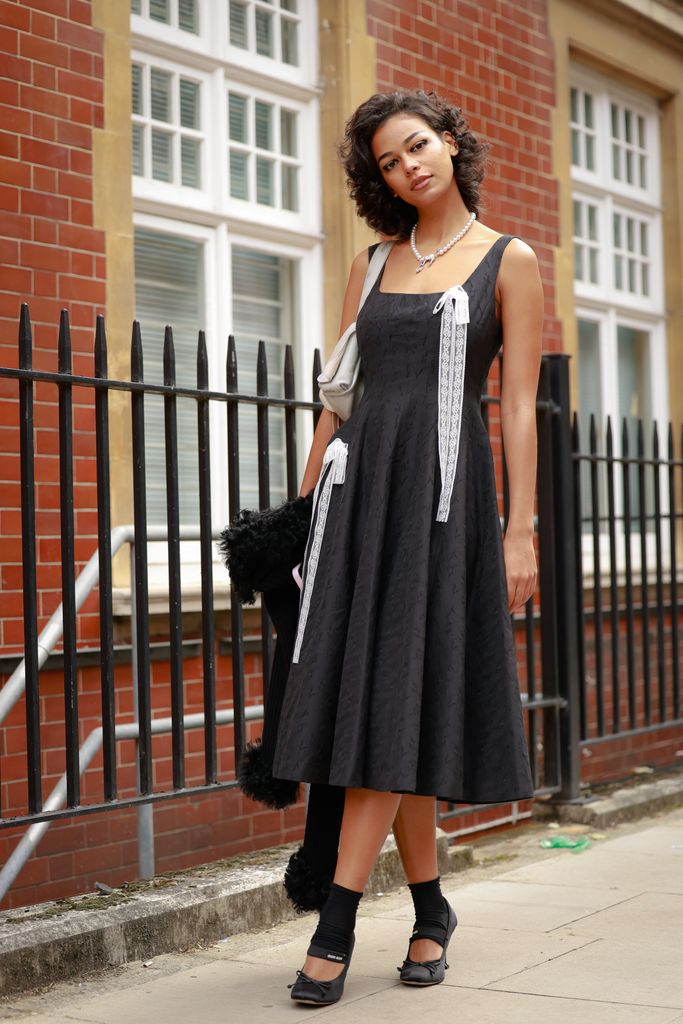 Pam Hughes wearing lace detailed black dress, Miu Miu black shoes and pearl necklace outside Yuhan Wang during London Fashion Week on September 20, 2025 in London, England