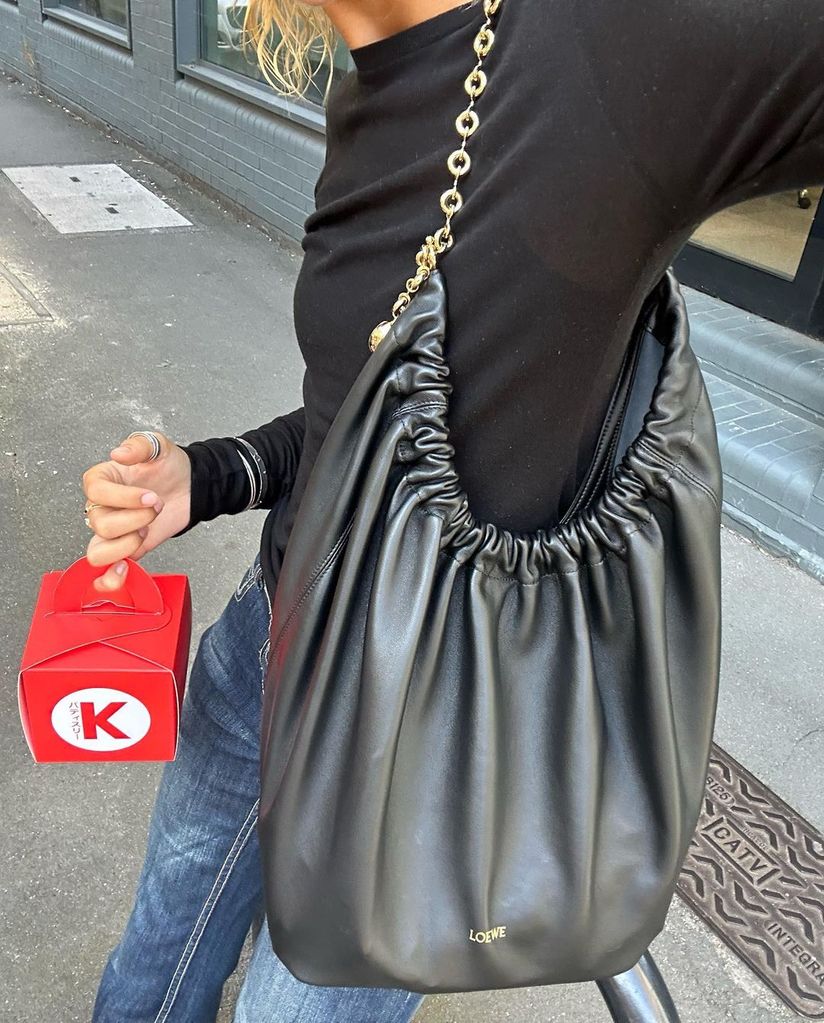 Mia Regan wears a black Loewe Squeeze bag to London Fashion Week