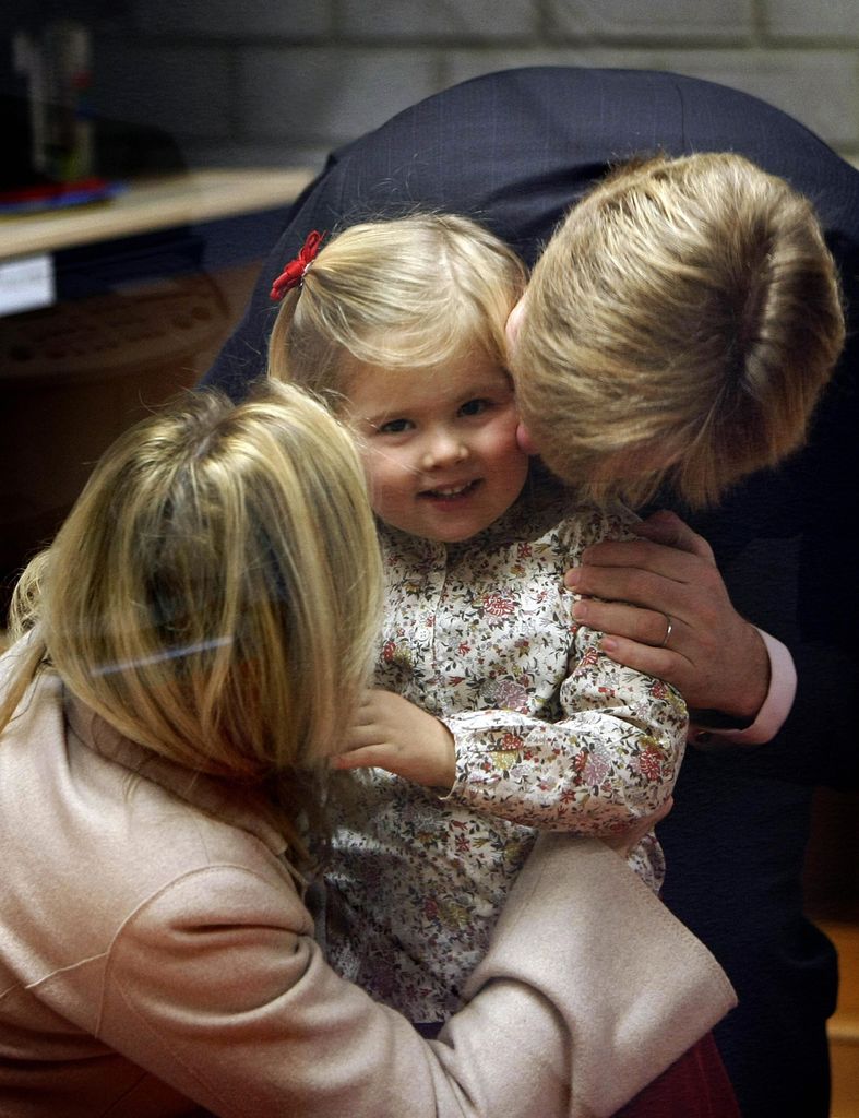 Princess Catharina-Amalia is hugged by her parents on her first day at school