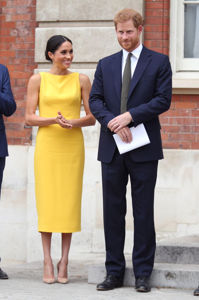 Meghan wearing yellow dress and Harry in suit