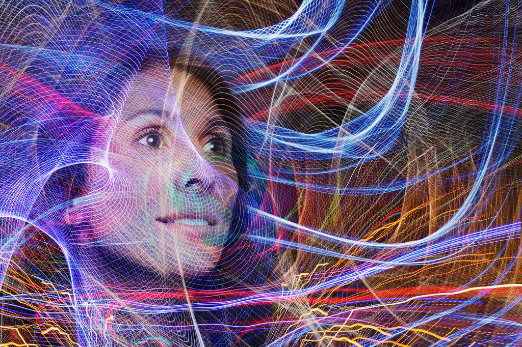 woman surrounded by glowing abstract lines representing neural pathways  