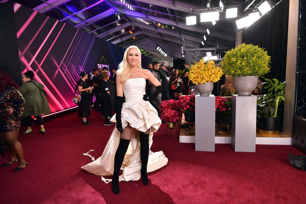 Gwen Stefani on red carpet in white dip hem dress