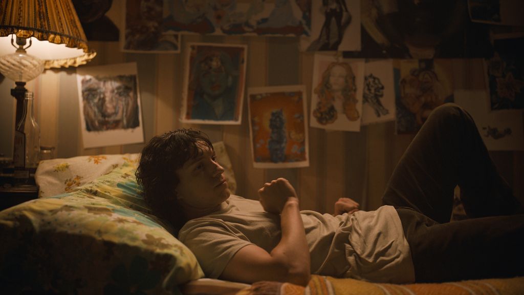 Tom Holland in character as Danny Sullivan lying on a bed