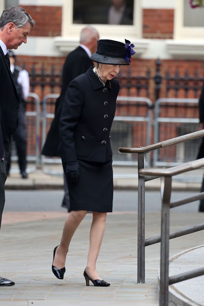Princess Anne in black outfit approaching stairs