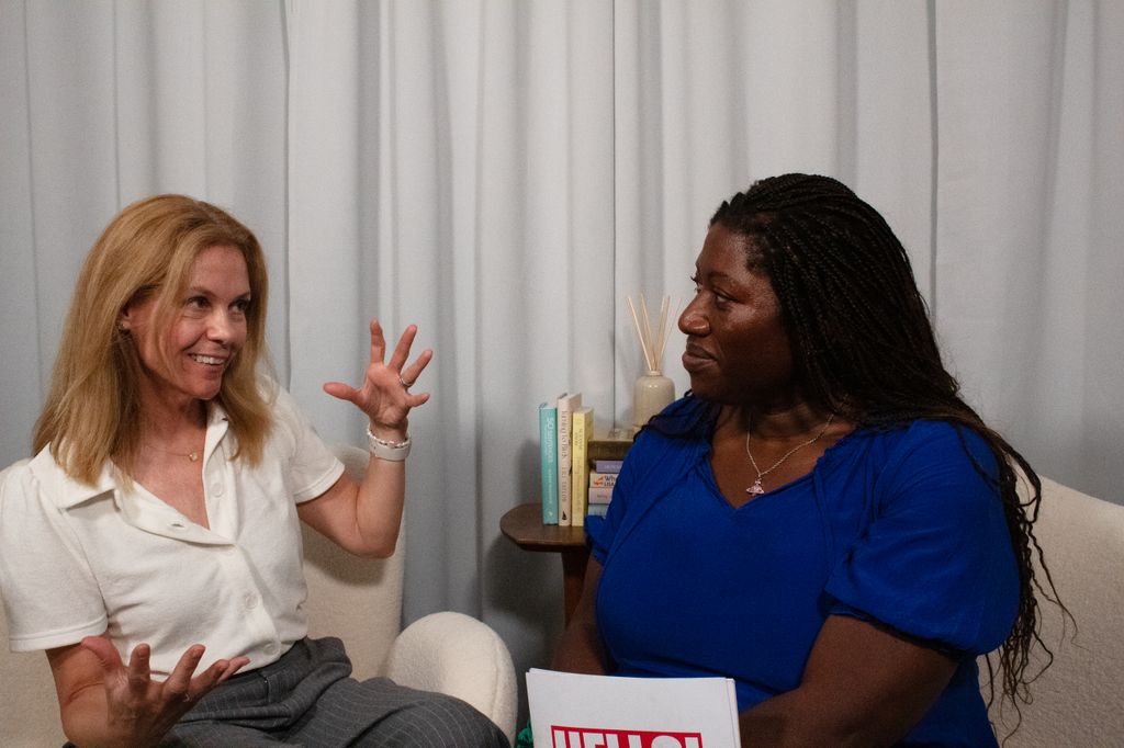 Two woman in midlife chatting animatedly in a podcast studio