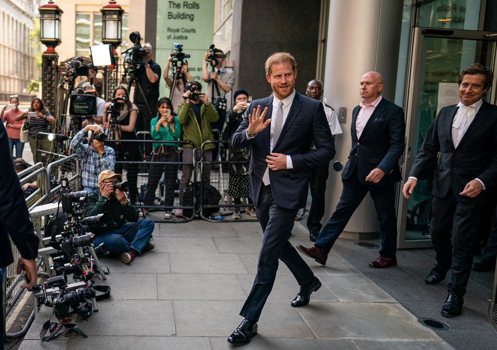 Prince Harry waves outside court