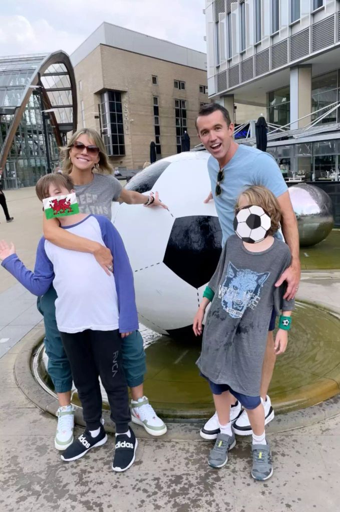 Kaitlin Olson and husband Rob McElhenney pose with their two sons  at Wrexham FC 