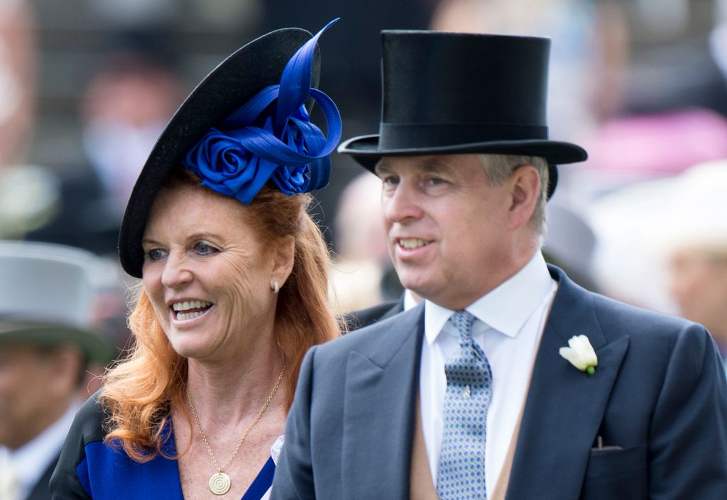Sarah wears a blue dress with a matching blue and black fascinator. Alongside her, Andrew Mountbatten-Windsor wears a suit and a black hat.