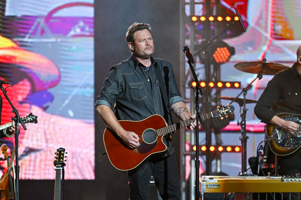 photo of blake shelton on stage holding a guitar