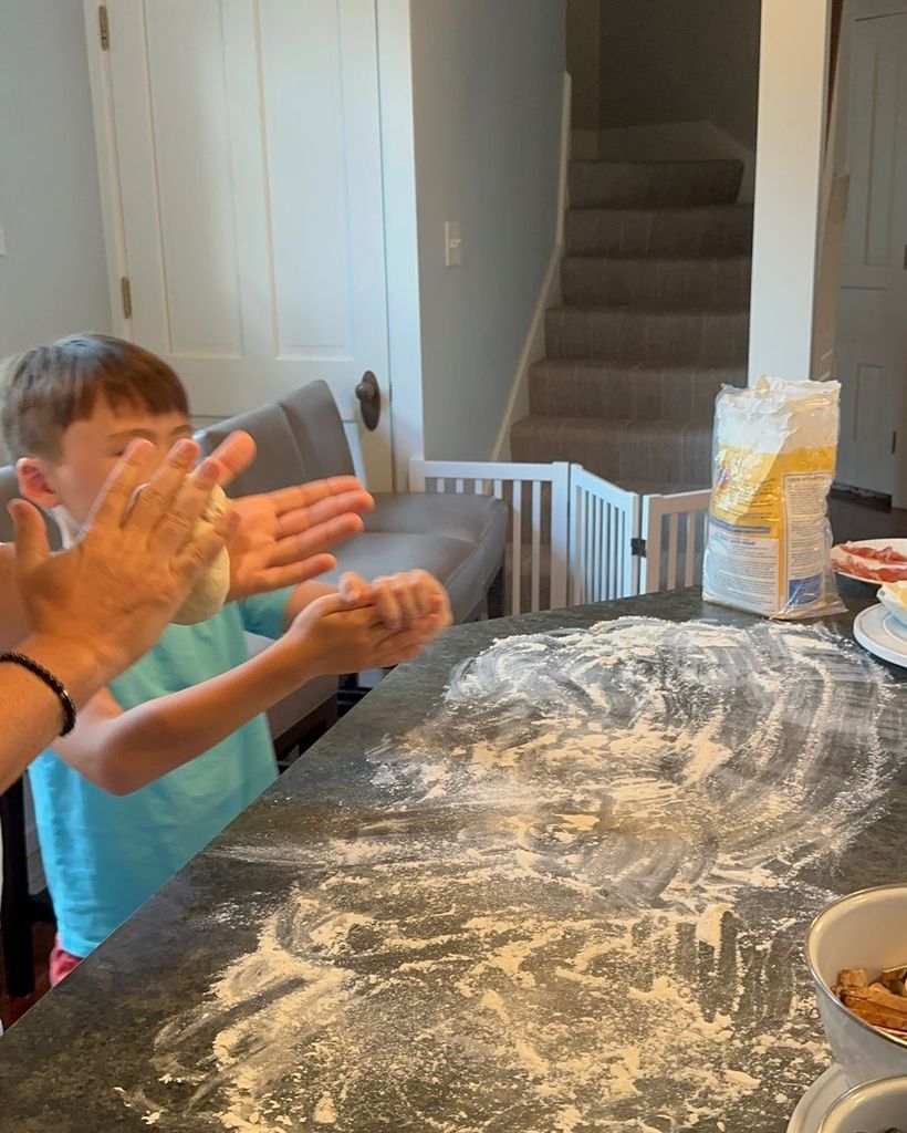 Wolfie making pizza at a kitchen table