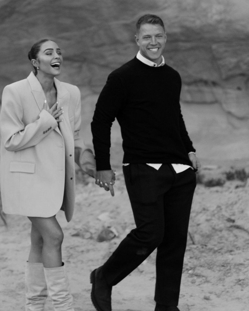 Olivia Culpo and Christian McCaffrey walking hand in hand after getting engaged
