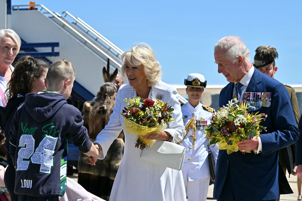 Król Karol III i królowa Camilla otrzymują kwiaty po przybyciu do placówki obronnej Fairbairn w Canberze 