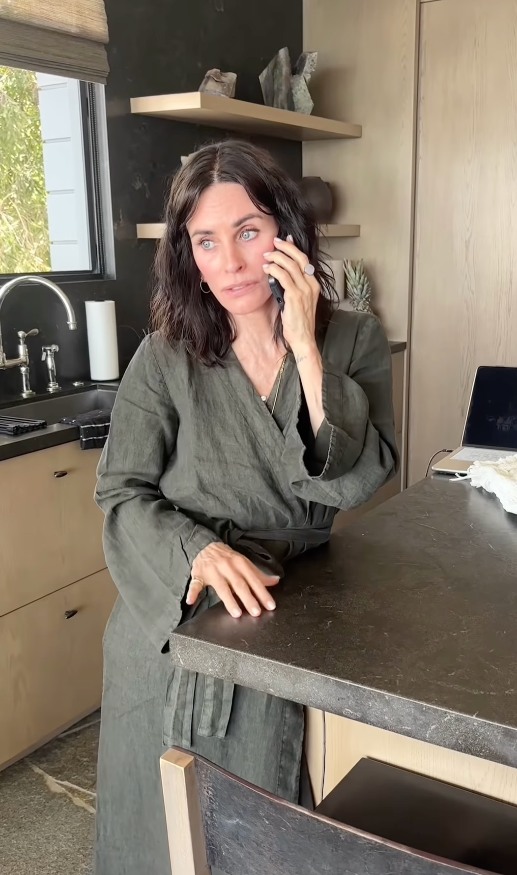 Courteney Cox standing on the phone in her Malibu kitchen