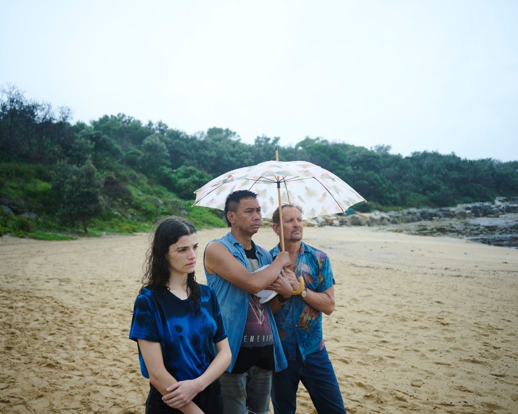 teenage girl and two men standing on beach
