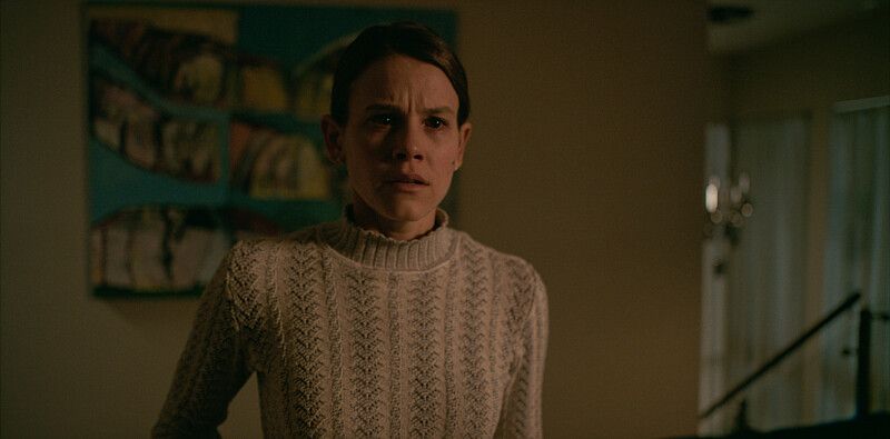 woman in jumper in dimly lit room