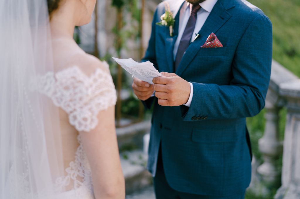 A groom reading to his bride at their wedding ceremony
