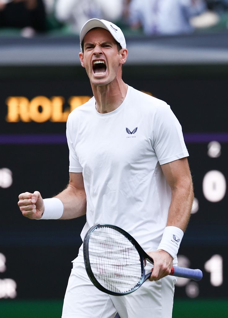 Andy Murray celebrates winning a game as he plays with Jamie Murray