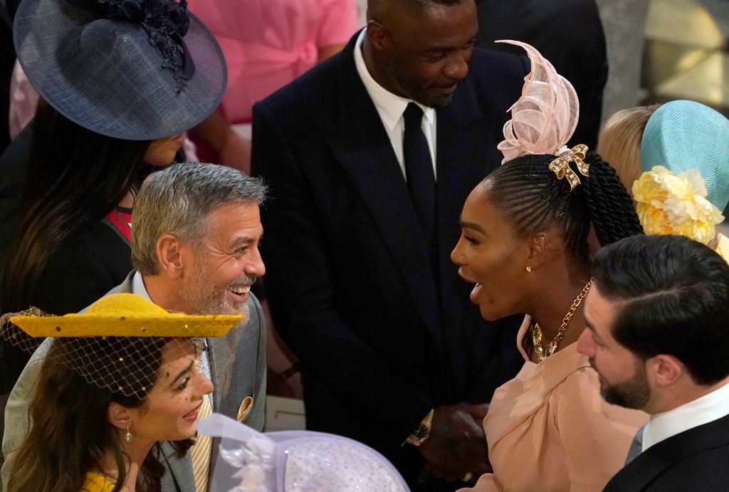 George Clooney greets Serena Williams at Windsor Castle for the wedding of Prince Harry and Meghan Markle at St Georges Chapel on May 19, 2018 in Windsor, England