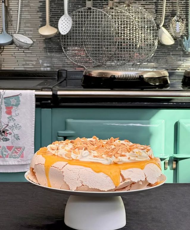 A cake lying in front of several units and utensils