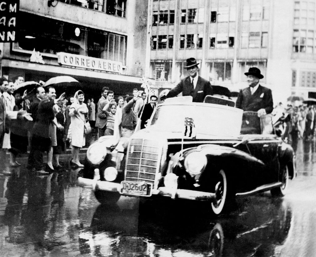 Duke Philip of Edinburgh waves to the crowd alongside Colombian President Alberto Lleras Camargo