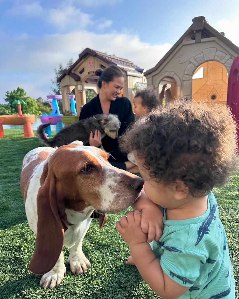 Chrissy Teigen with kids and dogs in backyard