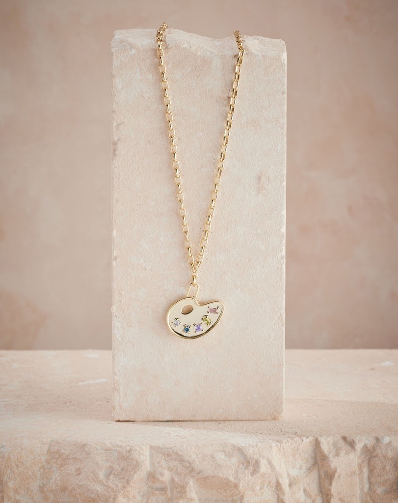 gold necklace with paint detailing in gemstones
