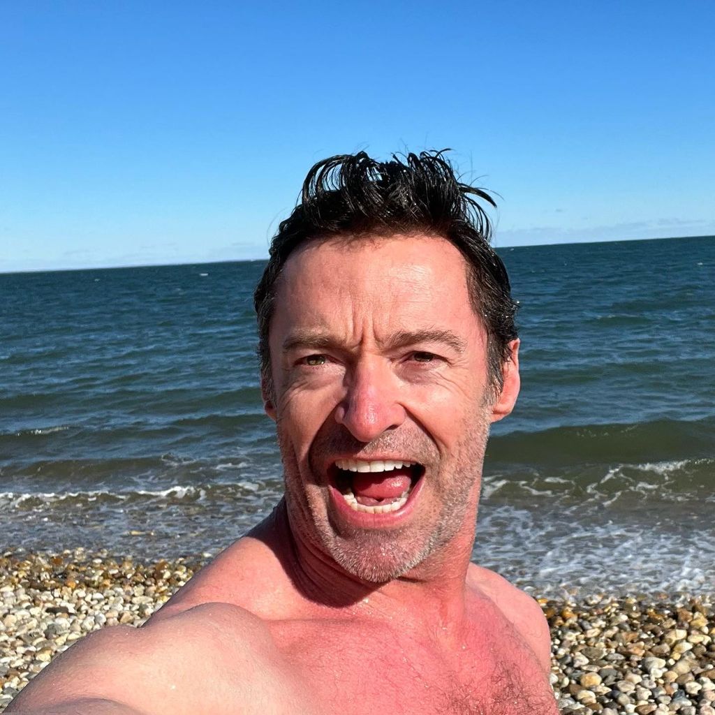 Hugh Jackman is shirtless at the beach as he goes swimming