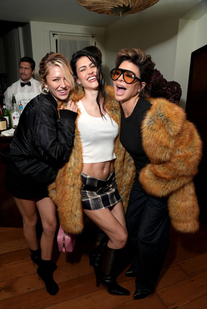 Delilah Belle Hamlin, Amelia Gray Hamlin and Lisa Rinna all laugh as they pose for the camera. Delilah is wearing a black jacket and mini skirt teamed with black ankle boots. 