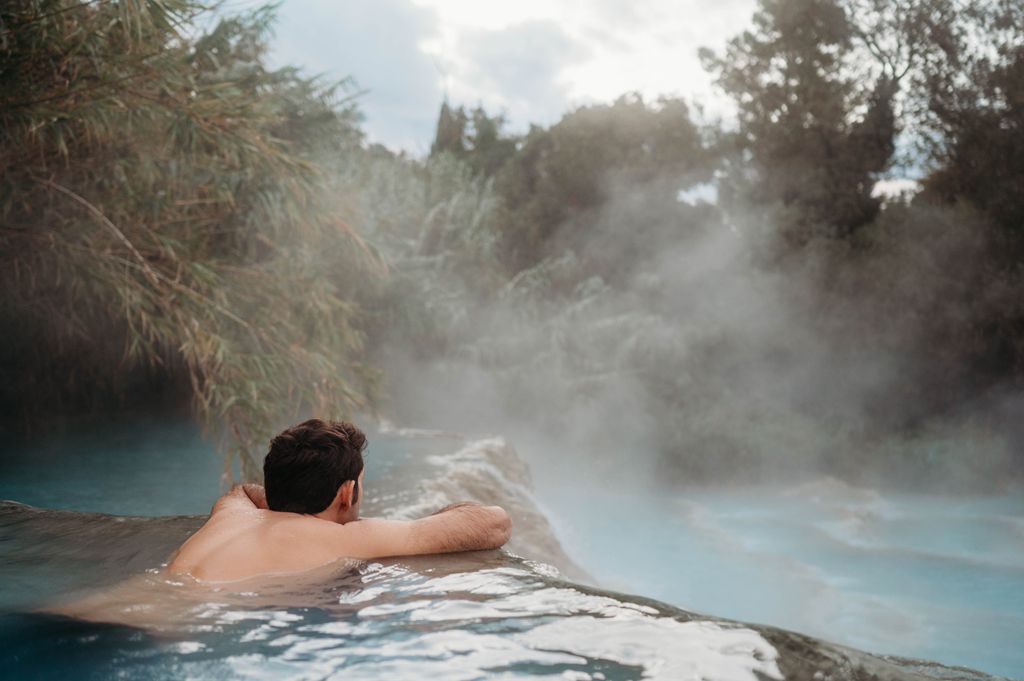 A man relaxing at the Cascate del Mulino in Tuscany