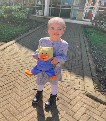 little girl holding duck toy