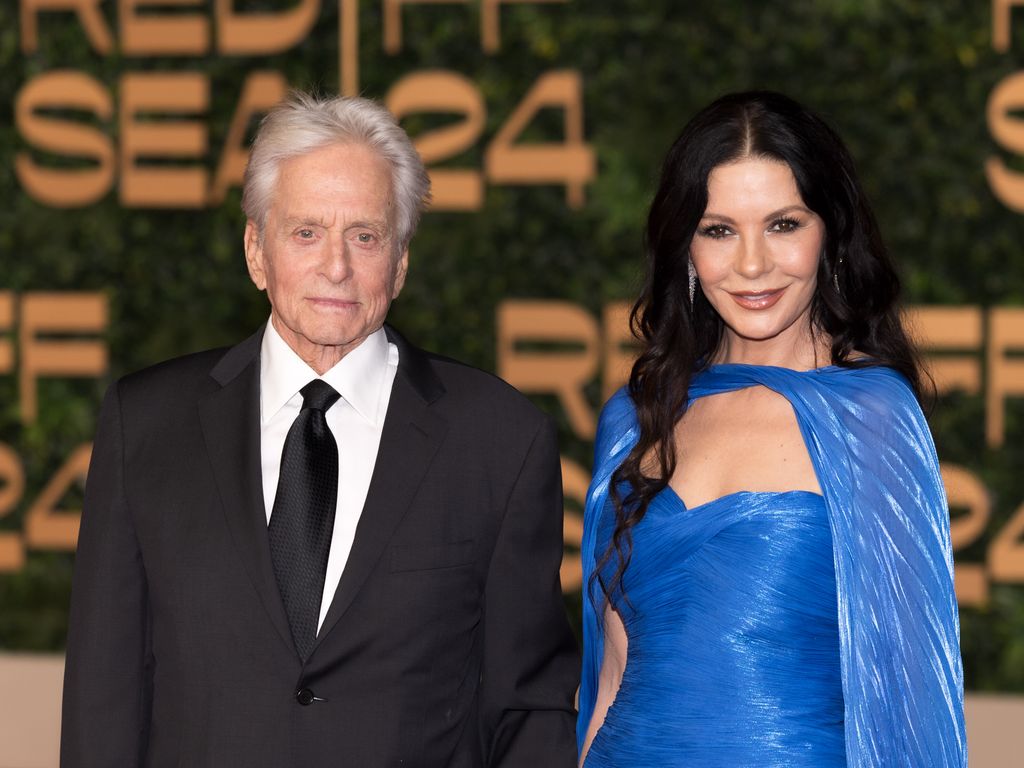 Michael Douglas in suit and Catherine Zeta-Jones in blue dress 