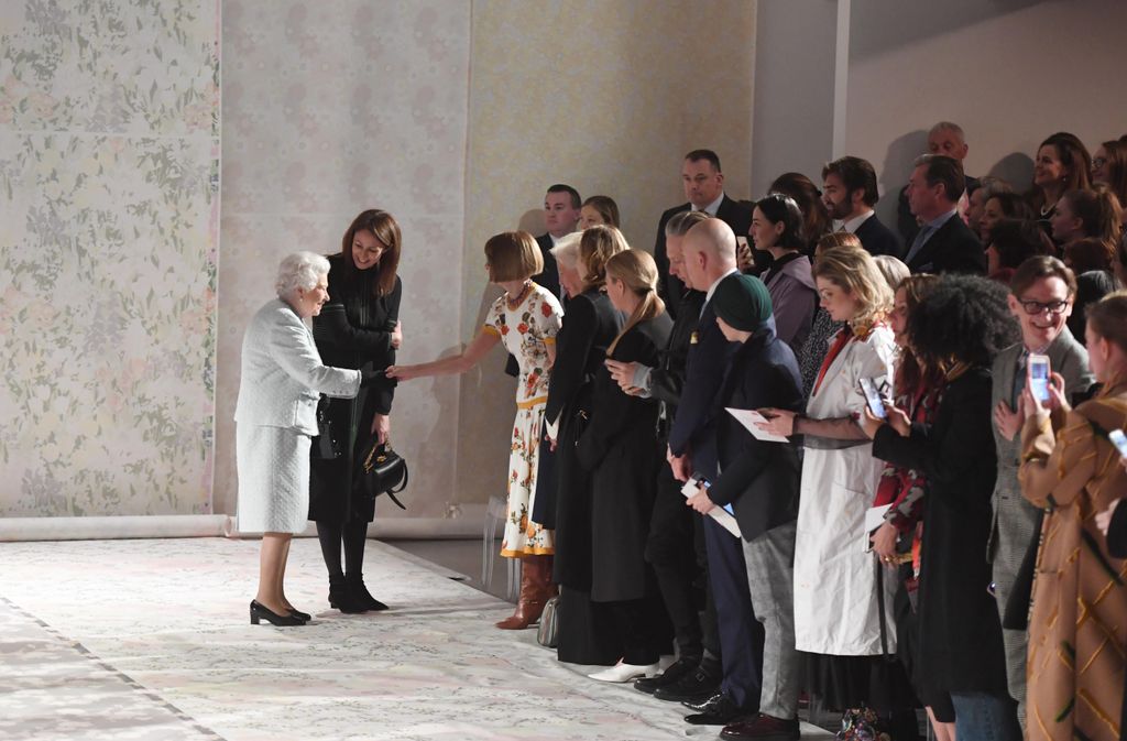 Queen Elizabeth is greeted by Anna Wintour and a crowd of well wishers at a London fashion show in February 2018.