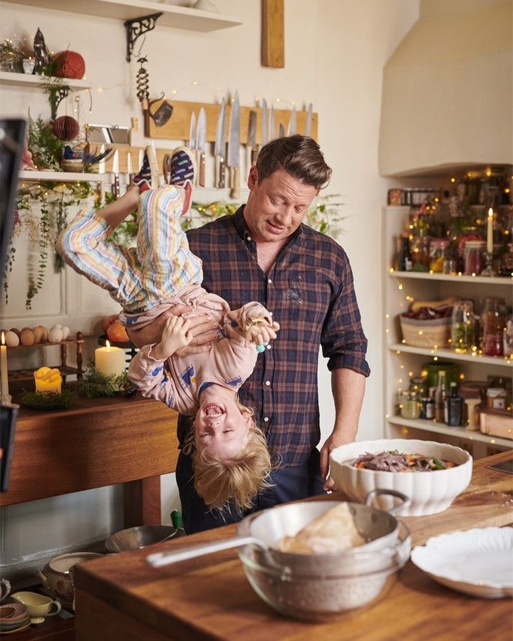 Jamie Oliver posing with son River in Essex home kitchen at Christmas