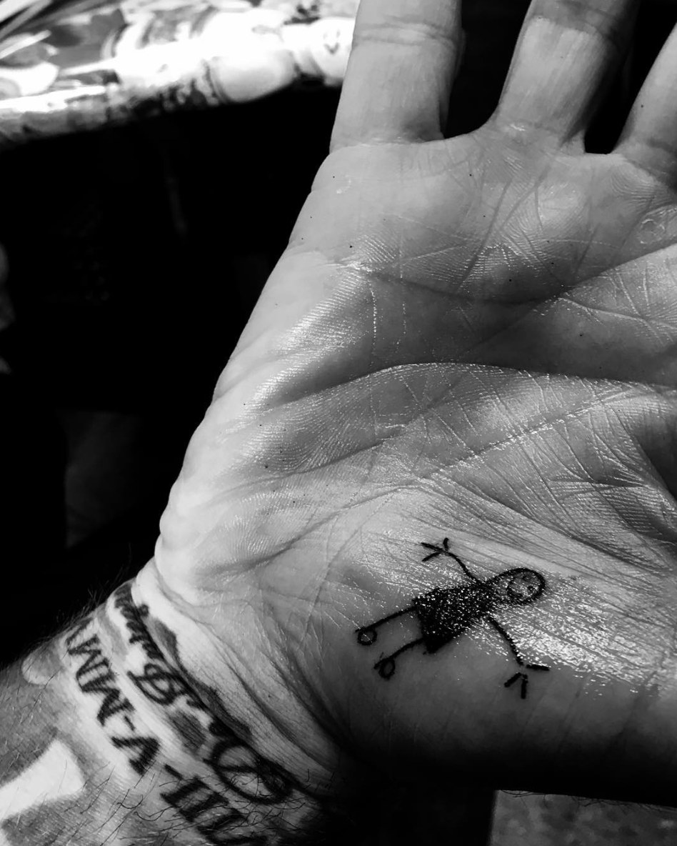 David Beckham's palm tattooed with a stick drawing