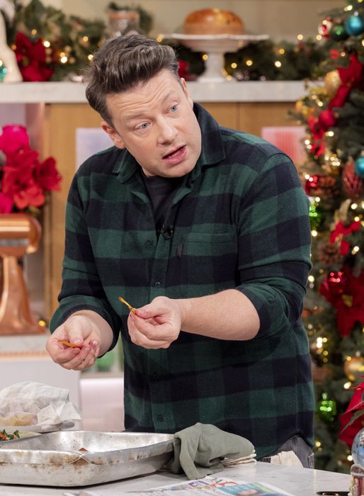 Jamie Oliver in a green check shirt cooking in a christmas setting